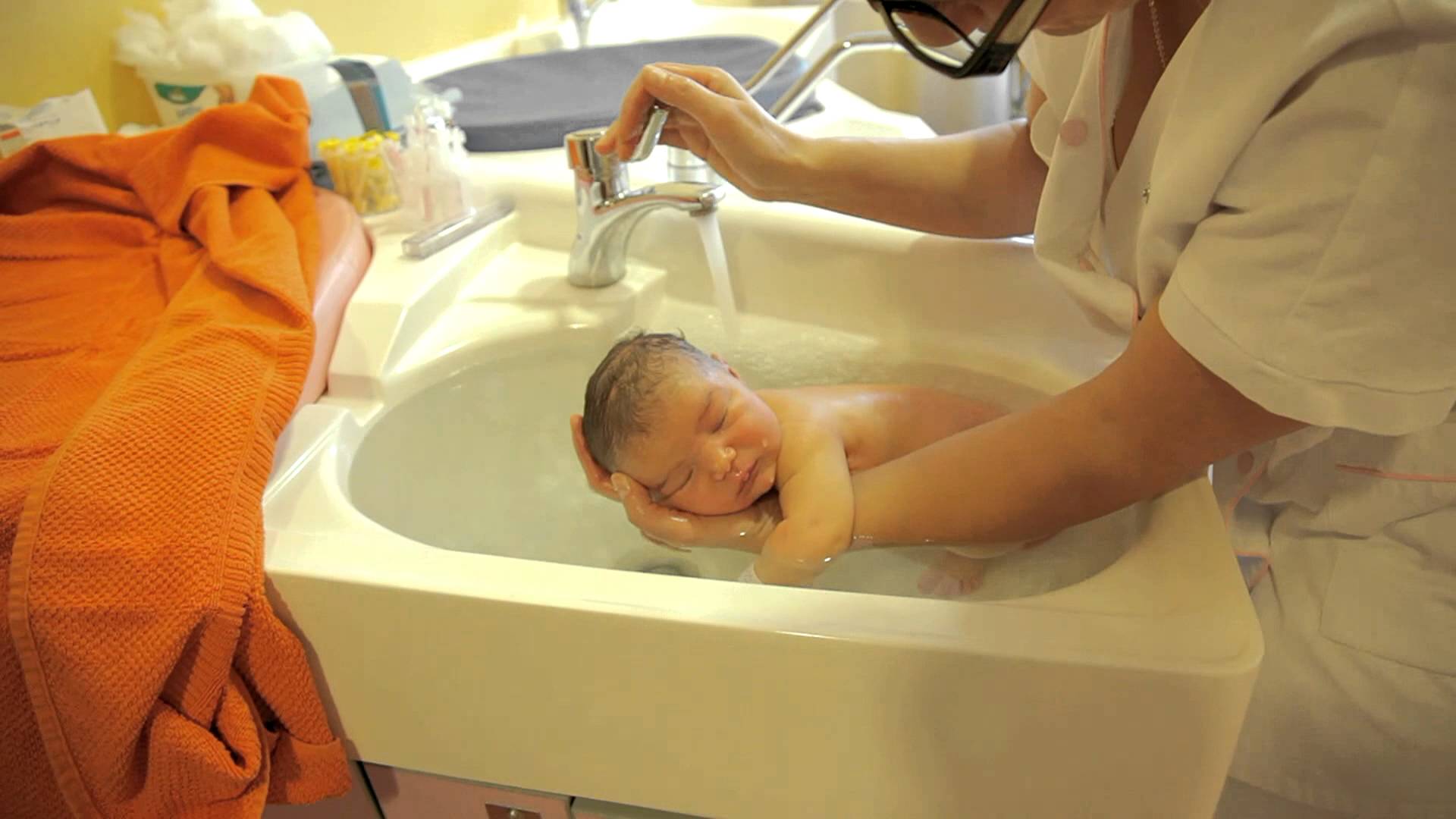 Как подмывать новорожденного в роддоме. Подмывание ребенка в раковине. Раковина для подмывания младенцев. Гигиеническая ванна ребенка. Купание новорожденного ребенка в роддоме.